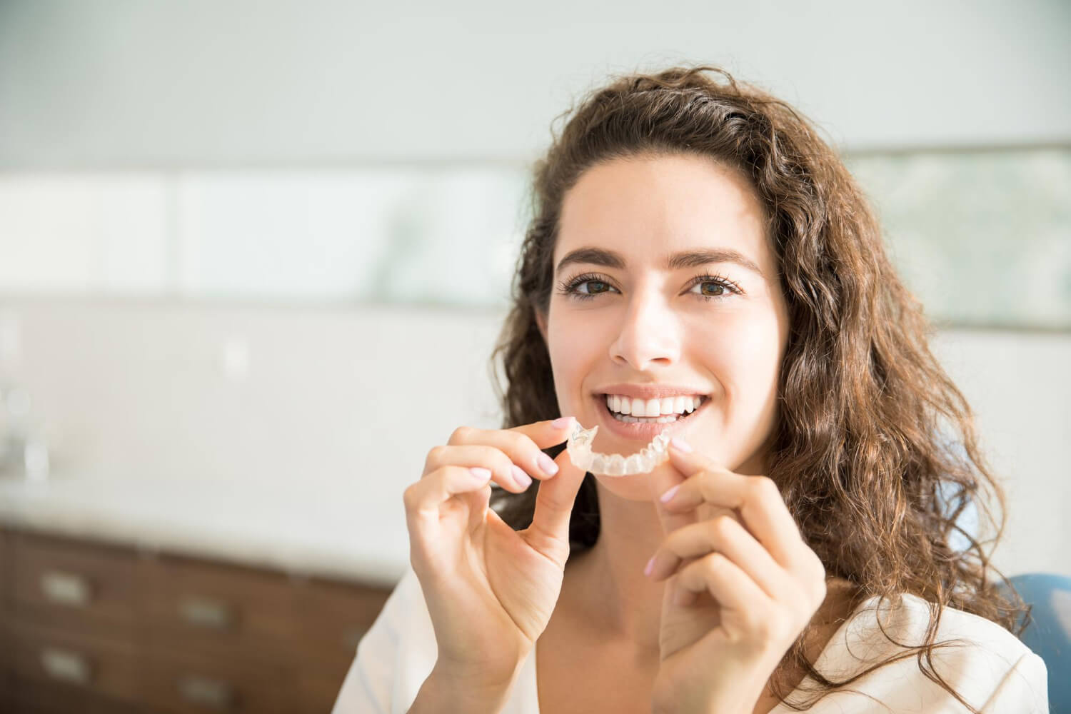portrait-beautiful-patient-holding-orthodontic-retainers-dental-clinic (1)