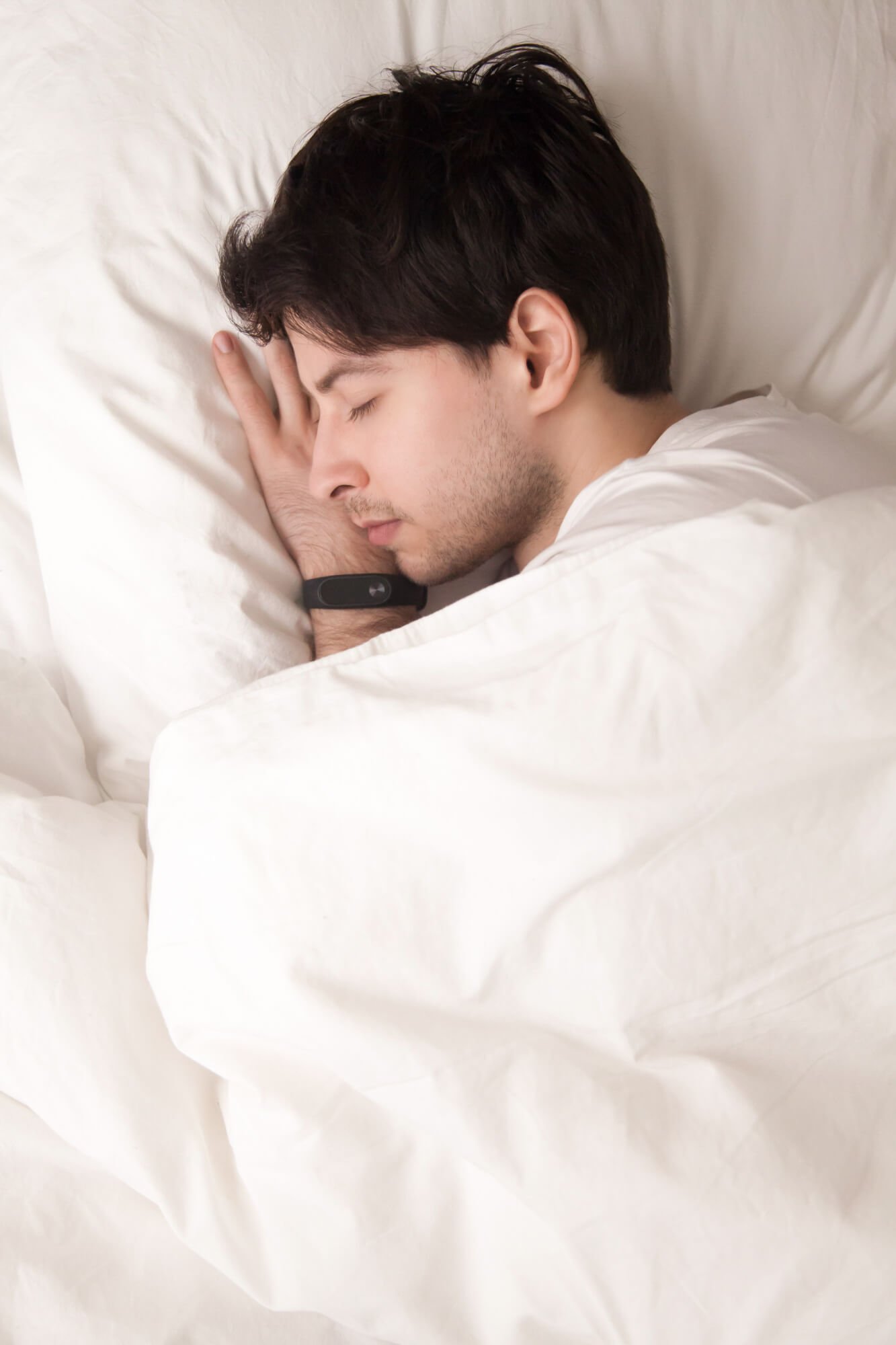 young-guy-sleeping-bed-wearing-smart-watch-sleep-tracker