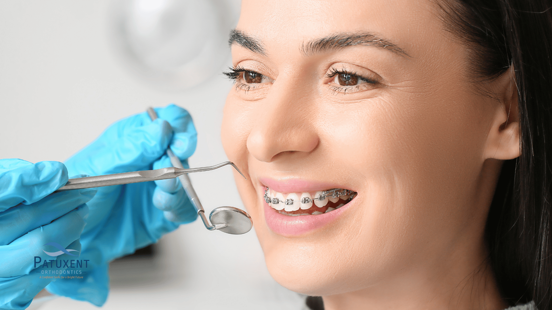 Woman with braces smiling during orthodontic appointment Woman with braces smiling during orthodontic appointment