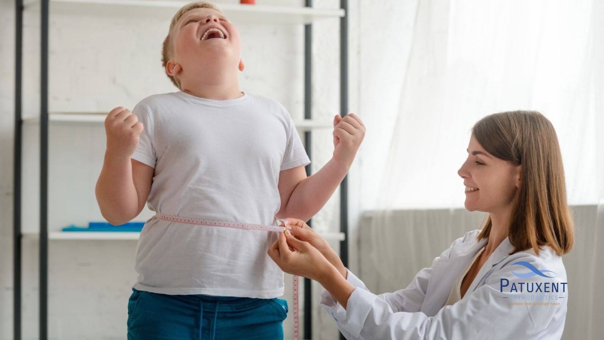 This is an image of a physician measuring a young boy's waistline